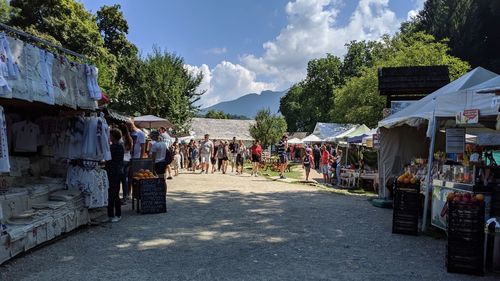 People at market stall against sky