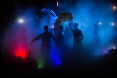 Silhouette people dancing in concert