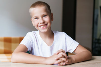 Portrait of cute generation z schoolboy in white t-shirt talking to webcam