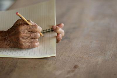Midsection of man holding ice cream on table