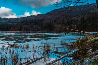 Scenic view of lake against sky during winter