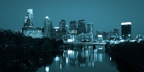 River amidst illuminated buildings against sky at night