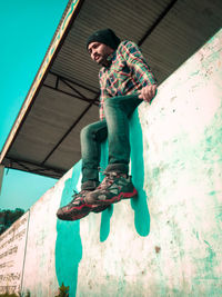 Low angle view of man standing against wall