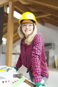 Portrait of smiling woman standing at construction site