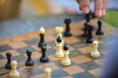 Man playing chess on a table outdoor.