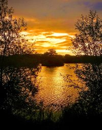 Scenic view of lake against orange sky