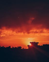 Silhouette buildings against sky during sunset