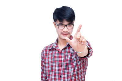 Portrait of young man standing against white background