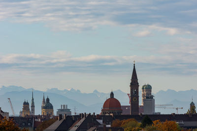 Buildings in city against cloudy sky
