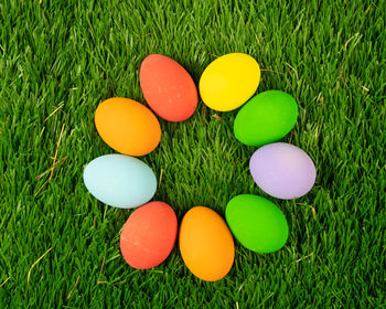 High angle view of multi colored eggs on field