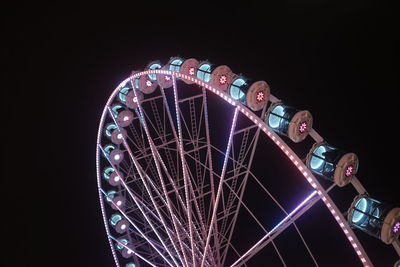 Low angle view of illuminated ferris wheel against sky at night