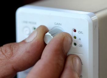 Cropped hand of person holding thermostat
