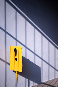 Exclamation mark in yellowsign infront of wall