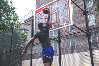 Young man playing basketball in court