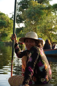 Portrait of mature woman sitting on boat with oar in lake