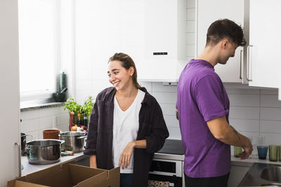 Couple unpacking boxes in kitchen