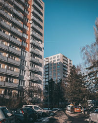 Cars on street by buildings against sky