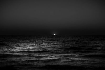 Scenic view of sea against clear sky at night