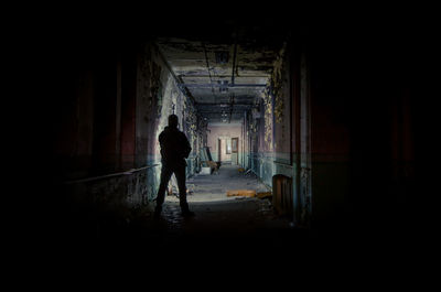 Silhouette man standing in abandoned building