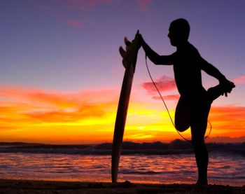 Silhouette of people on beach at sunset