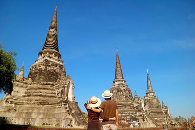 Couple impressed by the incredible historic pagoda of wat phra si sanphet in ayutthaya, thailand