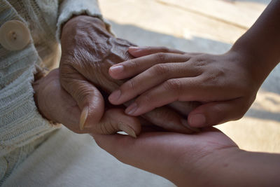 Midsection of couple holding hands