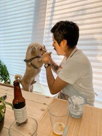 Side view of woman with dogs on table
