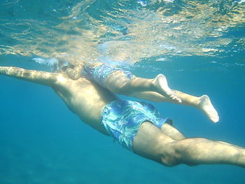 Low section of young woman swimming in pool