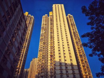 Low angle view of skyscrapers against clear blue sky