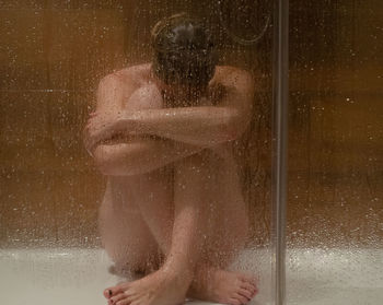 Water drops on woman in bathroom