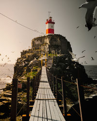 View of lighthouse amidst buildings against sky