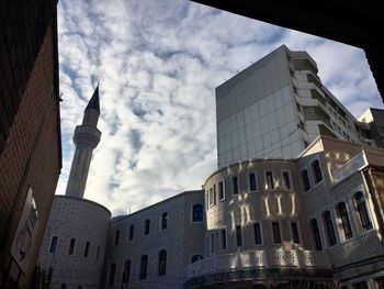 Low angle view of buildings against cloudy sky