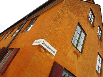 Low angle view of text on building against sky