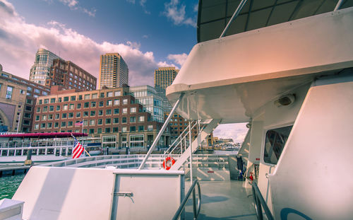 Boats moored in swimming pool against buildings in city