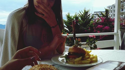 Close-up of woman having food on table