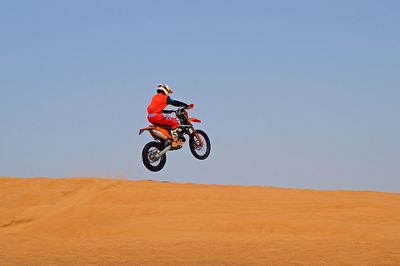 Man riding bicycle on sand