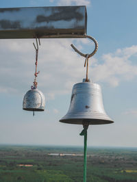 Street light hanging on field by sea against sky