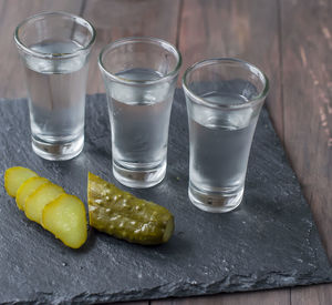 Close-up of pickled cucumbers in bowl on wooden table