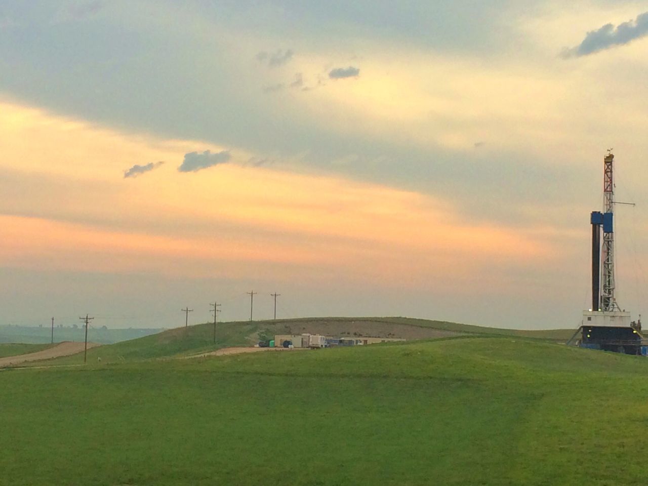 sky, sunset, grass, cloud - sky, field, landscape, built structure, scenics, tranquility, tranquil scene, architecture, beauty in nature, cloudy, nature, orange color, cloud, grassy, building exterior, idyllic, green color