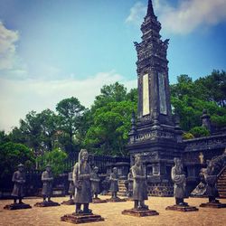 Statue in temple against cloudy sky