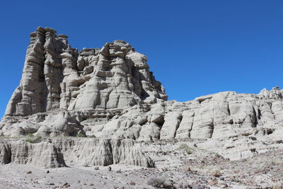 Low angle view of rocks on mountain against sky