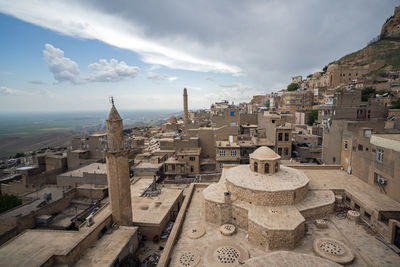 High angle view of old townscape against cloudy sky