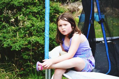 Portrait of girl sitting on trampoline