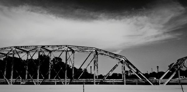 Low angle view of bridge against cloudy sky