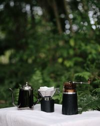 Wine bottles on table against trees