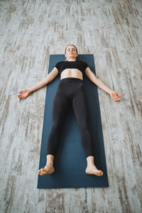 Full length of woman lying on hardwood floor