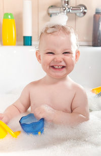 Portrait of girl playing with toys in bathtub