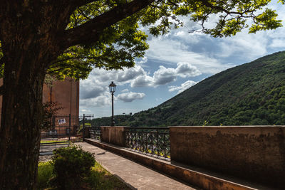 Railroad tracks by street against sky