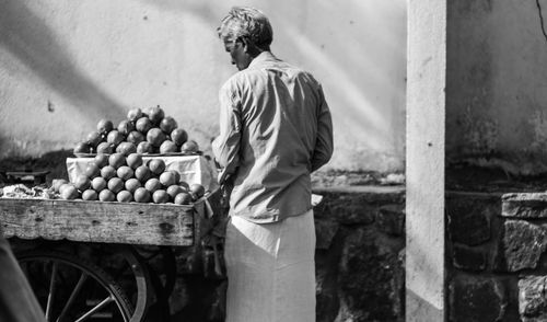 Rear view of man working at market