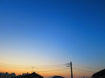 Electricity pylon against clear blue sky